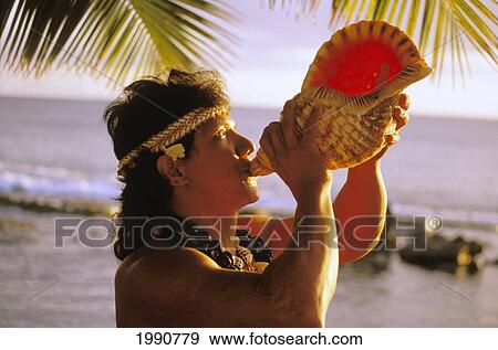 Stock Photo - Hawaii, Native Local Man At Ocean Blowing Conch Shell With Shell Haku. Fotosearch