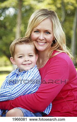 Stock Image - Hawaii, Oahu, A Mother And Son Sit Together In A Park.. Fotosearch