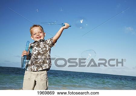 Stock Photo - Hawaii, Oahu, Adorable Little Boy With An Aloha Shirt Playing With Bubbles.. Fotosearch