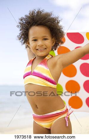 Stock Photo - Hawaii, Oahu, Adorable Little Girl Holding A Polka-Dot Towel Along The Waters Edge.. Fotosearch