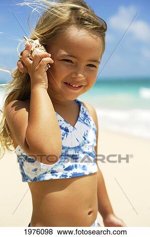 Hawaii, Oahu, Adorable Little Girl Holding Seashell Along The Waters Edge. View Large Photo Image Stock Photo - Hawaii, Oahu, Adorable Little Girl Holding Seashell Along The Waters Edge.. Fotosearch