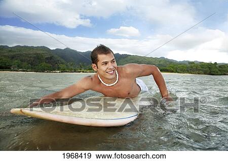Hawaii, Oahu, Aina Haina, Young Man Paddling On His Surfboard In The Water. View Large Photo Image Stock Photo - Hawaii, Oahu, Aina Haina, Young Man Paddling On His Surfboard In The Water.. Fotosearch