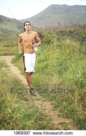 Stock Photo - Hawaii, Oahu, Atheltic Male Jogging On An Outdoor Field Walkway Path. Fotosearch