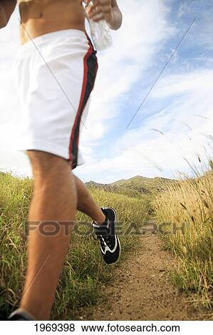 Stock Photo - Hawaii, Oahu, Atheltic Male Jogging On An Outdoor Field Walkway Path. Fotosearch