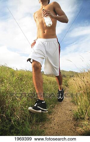 Stock Photo - Hawaii, Oahu, Atheltic Male Jogging On An Outdoor Field Walkway Path. Fotosearch