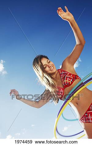 Stock Photo - Hawaii, Oahu, Attractive Young Woman On The Beach Hula Hooping.. Fotosearch