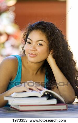 Stock Image - Hawaii, Oahu, Attractive Young Woman Educating Herself With Books.. Fotosearch