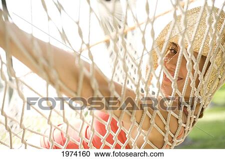 Stock Image - Hawaii, Oahu, Attractive Young Woman Laying In A Hammock.. Fotosearch