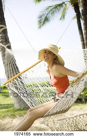 Stock Photography - Hawaii, Oahu, Attractive Young Woman Laying In A Hammock.. Fotosearch