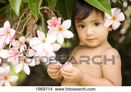 Picture - Hawaii, Oahu, Baby Girl Playing With Plumeria Flowers.. Fotosearch