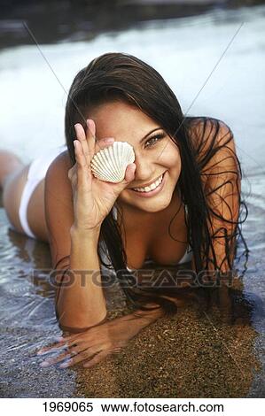 Hawaii, Oahu, Beautiful Female Holding A Coral Shell Over One Eye In The Water View Large Photo Image Stock Photography - Hawaii, Oahu, Beautiful Female Holding A Coral Shell Over One Eye In The Water. Fotosearch