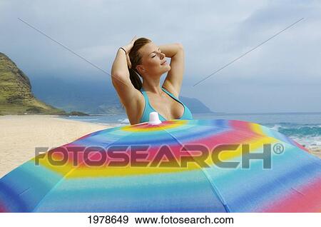 Stock Photo - Hawaii, Oahu, Beautiful Girl By Umbrella On The Beach.. Fotosearch