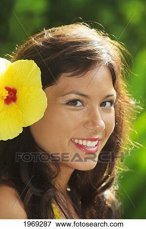 Stock Photo - Hawaii, Oahu, Beautiful Headshot Of A Young Girl With A Hibiscus In Her Ear.. Fotosearch