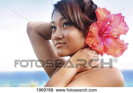 Stock Photo - Hawaii, Oahu, Beautiful Headshot Of A Young Girl With A Hibiscus In Her Ear.. Fotosearch