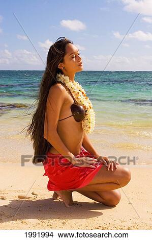Picture - Hawaii, Oahu, Beautiful Local Girl In Hula Costume Kneeling On The Beach.. Fotosearch
