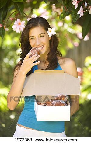Hawaii, Oahu, Beautiful Model Eating A Box Of Malasadas (Local Cuisine). View Large Photo Image Stock Photo - Hawaii, Oahu, Beautiful Model Eating A Box Of Malasadas (Local Cuisine).. Fotosearch