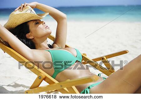 Stock Photo - Hawaii, Oahu, Beautiful Woman Sitting In Chair On The Beach.. Fotosearch