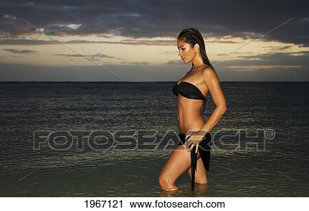 Hawaii, Oahu, Beautiful Woman Standing In Ocean Water At Sunset. View Large Photo Image Stock Image - Hawaii, Oahu, Beautiful Woman Standing In Ocean Water At Sunset.. Fotosearch
