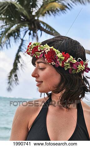 Stock Image - Hawaii, Oahu, Beautiful Woman Wearing Haku Lei By The Ocean Looks To The Side.. Fotosearch