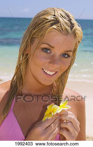 Hawaii, Oahu, Beautiful Young Woman Standing By The Ocean Holding Plumeria's At A Tropical Beach. View Large Photo Image Stock Image - Hawaii, Oahu, Beautiful Young Woman Standing By The Ocean Holding Plumeria's At A Tropical Beach.. Fotosearch