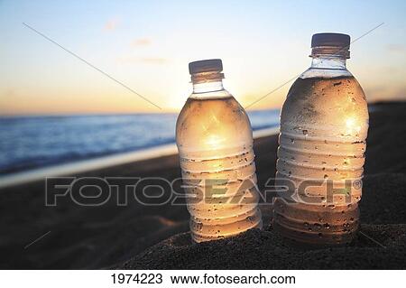 Stock Image - Hawaii, Oahu, Bottle Of Water On The Beach.. Fotosearch