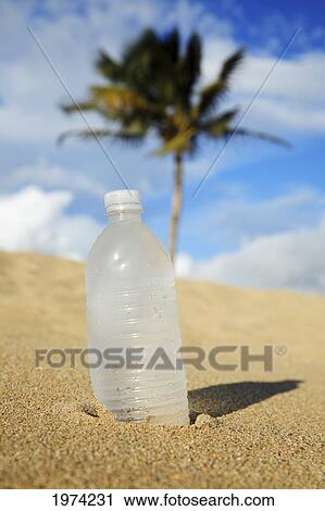 Stock Image - Hawaii, Oahu, Bottle Of Water On The Beach.. Fotosearch