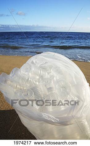 Stock Photo - Hawaii, Oahu, Bottles Of Water In A Trash Bag On The Beach.. Fotosearch