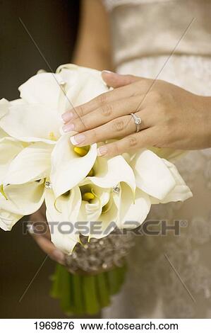 Stock Photograph - Hawaii, Oahu, Bride Showing Her Bouquet And Wedding Ring.. Fotosearch
