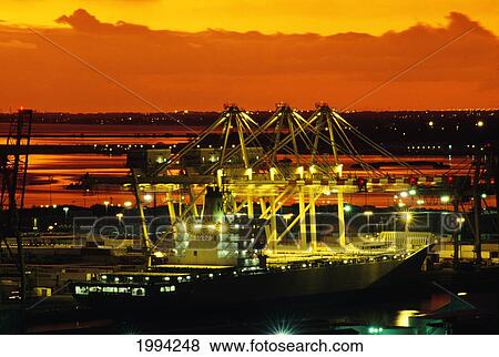 Stock Photo - Hawaii, Oahu, Bright Lights Of A Container Ship At Dusk In Honolulu Harbor.. Fotosearch