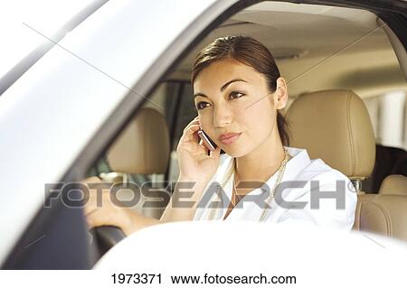 Stock Image - Hawaii, Oahu, Business Woman On The Phone In Her Car.. Fotosearch