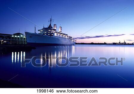 Stock Photograph - Hawaii, Oahu, Cruise Ship At Twilight In Honolulu Harbor, Reflections On Calm Ocean A49E. Fotosearch