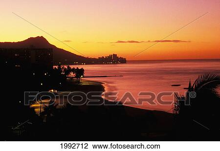 Stock Image - Hawaii, Oahu, Diamond Head At Dawn, Lights, Waikiki Beach, Orange And Pink Sky. Fotosearch