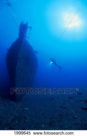Stock Photography - Hawaii, Oahu, Diver Off Wreck Mahi With Sunburst In Blue Water, View From Afar. Fotosearch