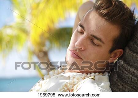 Hawaii, Oahu, European Male Leaning Against A Palm Tree And Relaxing At A Tropical Beach. View Large Photo Image Stock Photo - Hawaii, Oahu, European Male Leaning Against A Palm Tree And Relaxing At A Tropical Beach.. Fotosearch