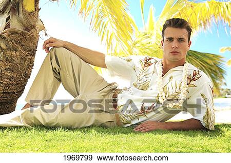 Hawaii, Oahu, European Male Leaning Against A Palm Tree And Relaxing At A Tropical Beach. View Large Photo Image Stock Photo - Hawaii, Oahu, European Male Leaning Against A Palm Tree And Relaxing At A Tropical Beach.. Fotosearch