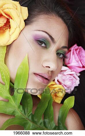 Stock Photo - Hawaii, Oahu, Fashion Model Poses Among Flowers And Leaf.. Fotosearch