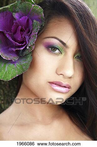 Stock Photograph - Hawaii, Oahu, Fashion Model Poses With Plant Behind Ear.. Fotosearch