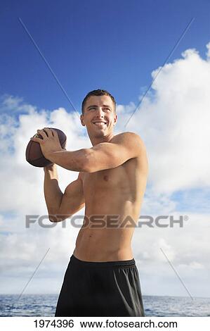 Hawaii, Oahu, Fit Male Holding A Football At The Tidepool. View Large Photo Image Stock Photograph - Hawaii, Oahu, Fit Male Holding A Football At The Tidepool.. Fotosearch
