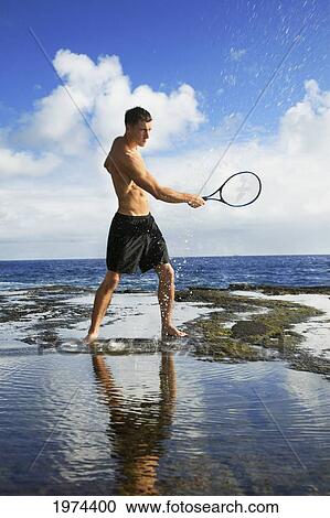 Hawaii, Oahu, Fit Male Swinging A Tennis Racket At The Tidepool. View Large Photo Image Stock Image - Hawaii, Oahu, Fit Male Swinging A Tennis Racket At The Tidepool.. Fotosearch
