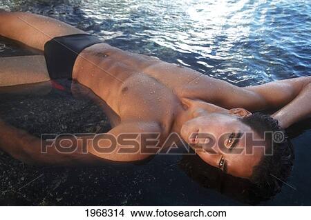 Picture - Hawaii, Oahu, Fit Young Male Enjoying A Warm Day In A Tidepool.. Fotosearch