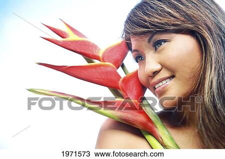 Stock Image - Hawaii, Oahu, Headshot Of Beautiful Asian Woman With Red Heliconia Flower.. Fotosearch