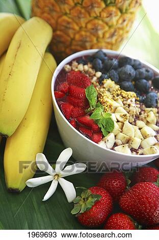 Stock Image - Hawaii, Oahu, Healthy And Organic Berry Acai Bowl Next To Assorted Fruits.. Fotosearch