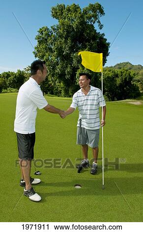 Stock Image - Hawaii, Oahu, Honolulu, Pali Golf Course, A Local Golfer Congratulates His Friend After Making A Good Shot At Hole 5.. Fotosearch