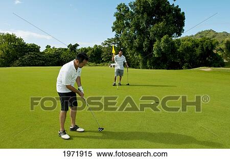 Stock Photography - Hawaii, Oahu, Honolulu, Pali Golf Course, A Local Golfer Puts At The Fifth Hole With His Friend.. Fotosearch