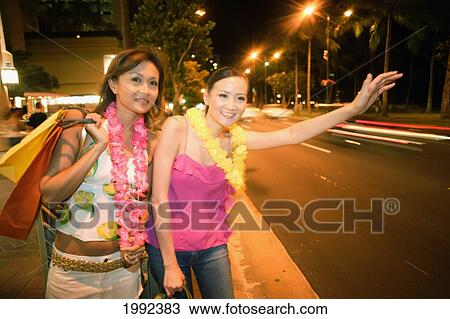 Hawaii, Oahu, Honolulu, Two Female Japanese Tourists Hail A Taxi In Waikiki. View Large Photo Image Stock Image - Hawaii, Oahu, Honolulu, Two Female Japanese Tourists Hail A Taxi In Waikiki.. Fotosearch