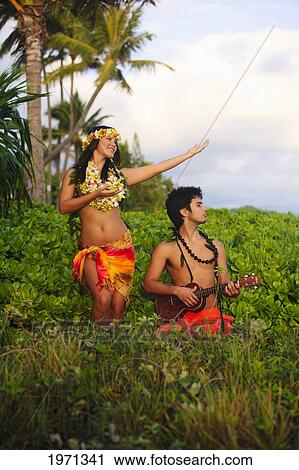 Stock Image - Hawaii, Oahu, Hula Dancer Couple In Tropical Setting.. Fotosearch