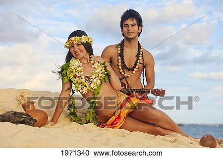Hawaii, Oahu, Hula Dancer Couple Lounging In Sand Along Beach Shoreline. View Large Photo Image Stock Image - Hawaii, Oahu, Hula Dancer Couple Lounging In Sand Along Beach Shoreline.. Fotosearch