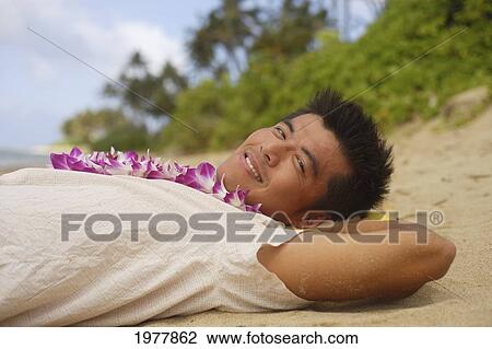 Hawaii, Oahu, Japanese Man Wearing Lei, Laying On Beach. View Large Photo Image Stock Image - Hawaii, Oahu, Japanese Man Wearing Lei, Laying On Beach.. Fotosearch
