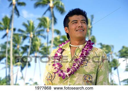 Stock Photo - Hawaii, Oahu, Japanese Man Wearing Lei, Palm Trees In Background.. Fotosearch