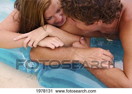 Stock Image - Hawaii, Oahu, Kailua Beach, Couple Lay On Inflatable Rafts On The Beach.. Fotosearch